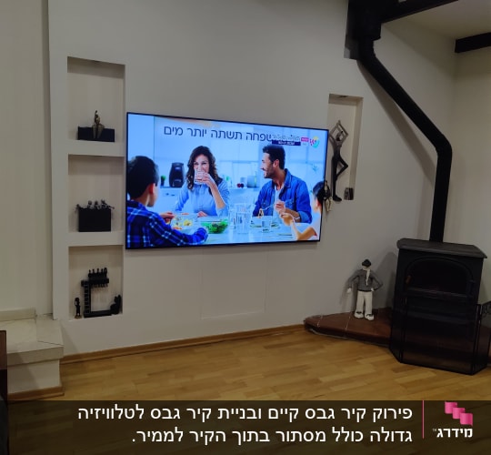 קיר גבס עם טלוויזיה תלויה ומדף קטן